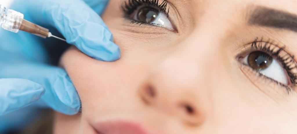 Rostro de mujer recibiendo inyección de rellenos dérmicos faciales